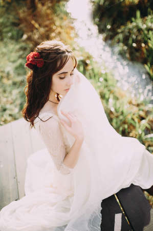 beautiful bride in a stylish light dress posing on the background of the riverの写真素材