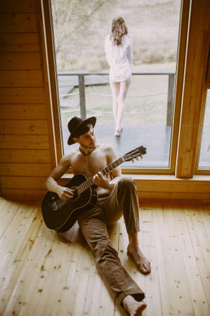 the guy in the hat plays the guitar. girl in the back dressの写真素材