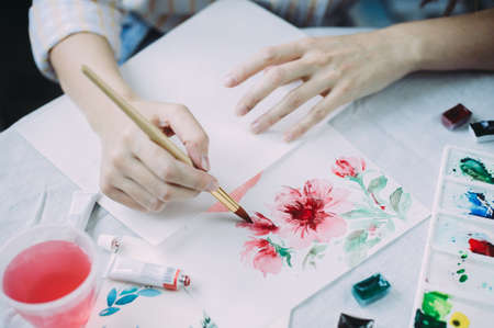 Beautiful girl artist paints with watercolors in a bright studio. Art. Drawingの写真素材