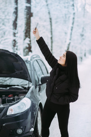 girl calls on the phone near a broken car. waiting for technical assistance