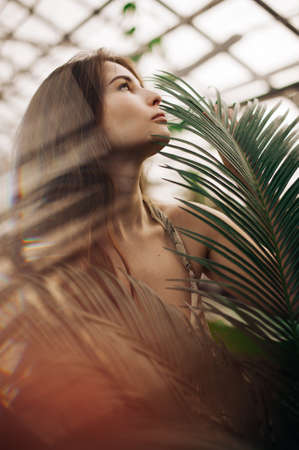 portrait of a beautiful stylish girl in a green batanic gardenの写真素材