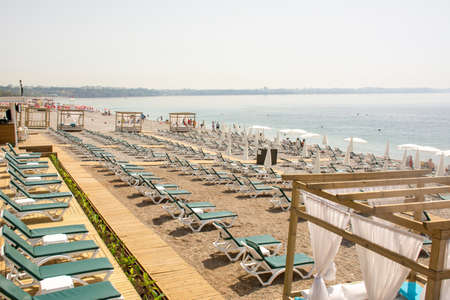 The tourist season is open, very few tourists have arrived, there are many empty sunbeds and beach chairs. Konyaalti Beach, Antalya, Turkey.の写真素材