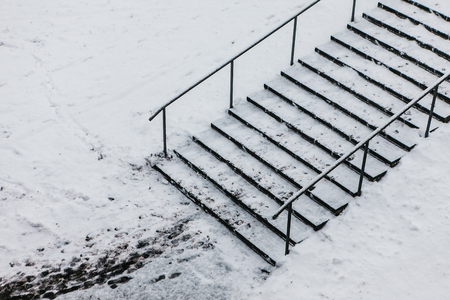 Dangerous stairs covered in winter snow. Minimalistic monochrome photo.の写真素材