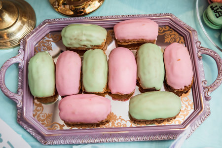 colored eclairs on a metal tray, traditional French dessert