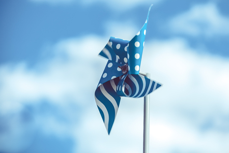 Blue pinwheel on sky background with few cloudsの写真素材