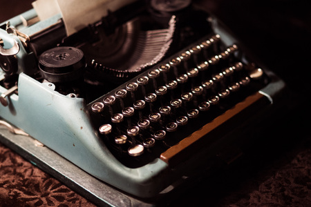 old typewriter in a dark room with dim warm lightの写真素材