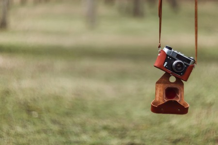 Vintage film camera on boulder over blurred nature background. Outdoor. Retro picture styleの写真素材