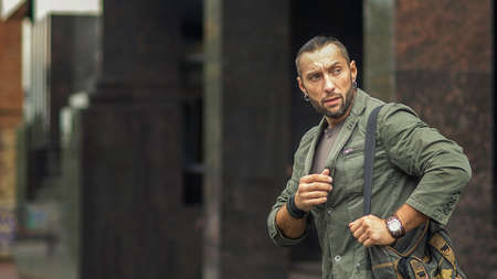 Portrait of young stylish man with bag in the street, life styleの写真素材