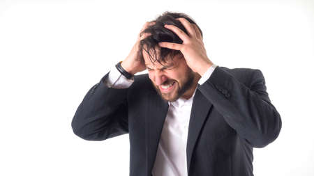 the businessman has a strong headache. He holds his hands on his head and closed his eyes in pain....