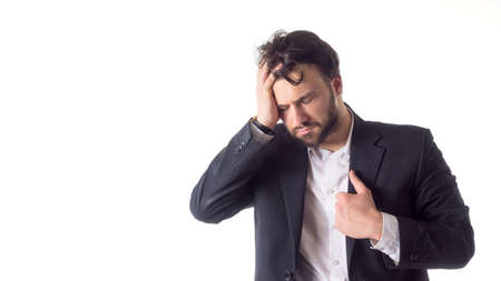 Close up portrait of a young bearded man suffering from a strong headache isolated over white background.の写真素材