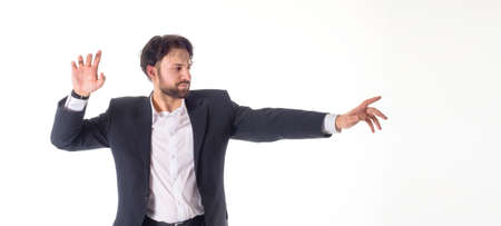 Happy smiling young man with a phone presenting and showing your text or product isolated on white backgroundの写真素材