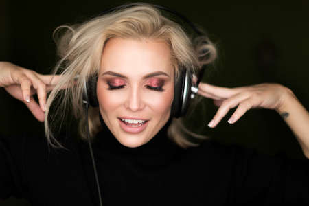 Studio portrait of a girl in headphones listening musicの写真素材