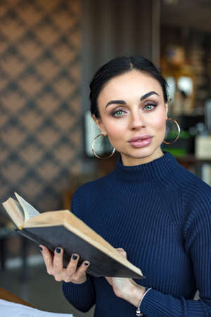 Portrait of female teacher holding bookの写真素材
