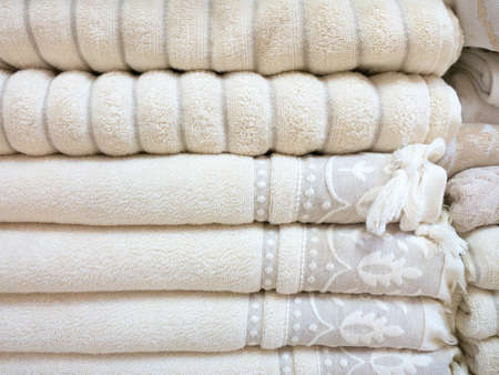 Stack of colorful terry towels folded. Shop Home. Numerous towels stacked and folded on the shelves of a storeの写真素材