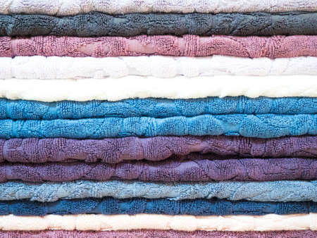 Stack of colorful terry towels folded. Shop Home. Numerous towels stacked and folded on the shelves of a storeの写真素材