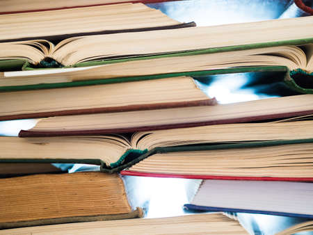 a lot of opened old and used hardback books or text books. Books and reading are essential for self...