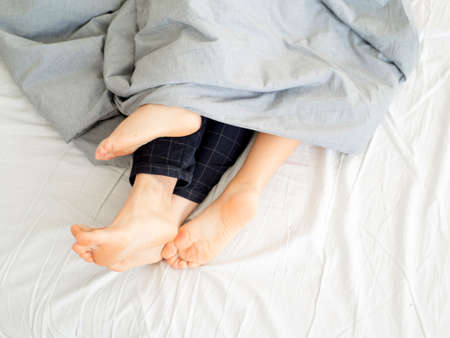 Close up of feet couple sleeping on a bed at home. Feet of couple in comfortable bed , Close up of...