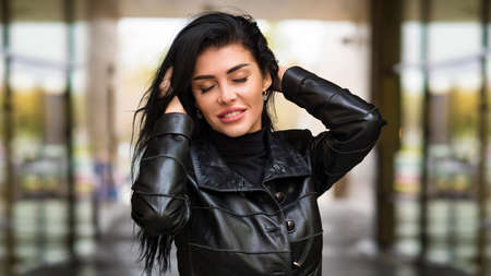 Urban woman walking in the city street during cold autumn dayの写真素材