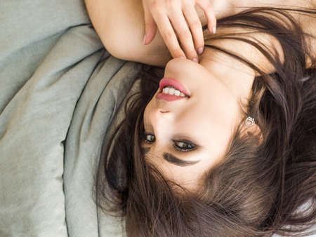 Charming woman Smile face close up and she lying on the bed in the morning. Skin care conceptの写真素材