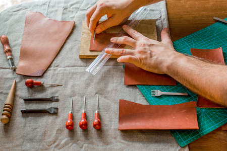 Working process of the leather bag for money or messenger in the leather workshop by master...