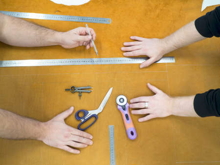 Hands of the master and studend. Marking leather for making bags, purses or shoes.の写真素材