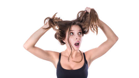 Upset surprised woman with tangled hair. Hair health concept.の写真素材