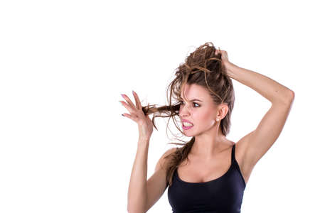Young woman is unhappy with split ends of her hair. Hair health concept.の写真素材