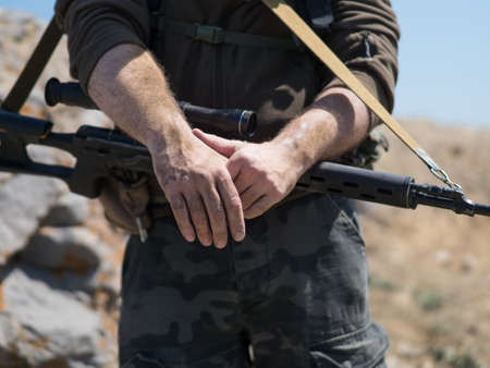 Close up view of a snipers hands. War conflict.の写真素材