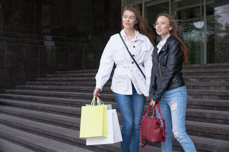 Smiling young women with shopping bags. shopping and fun concept.
