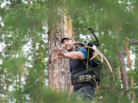 View of a hunter in the woods carries moose horns on his backの写真素材