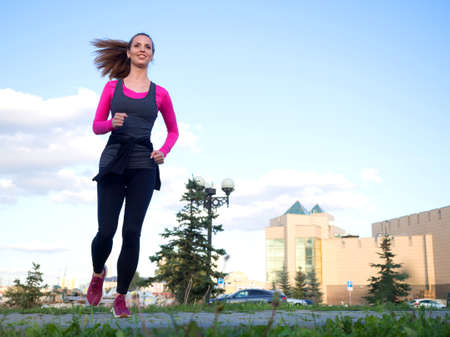 Woman running in a city park. Healthy lifestyle concept.の写真素材