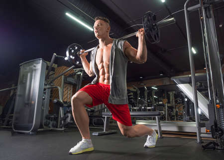 Middle aged man doing exercise for legs. Man working out legs with barbell.の写真素材