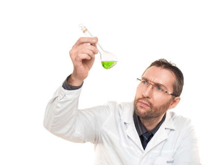 Male doctor carefully looking in green liquid In beaker. Isolated on white.
