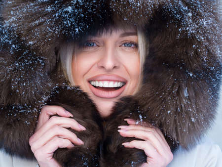 Close up portrait of a happy woman in fur hood looking at camera.の写真素材