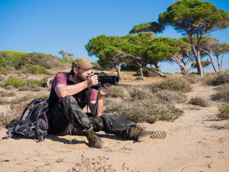 Man photographer in savanna taking a picture of a wild life of an animals.の写真素材