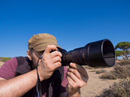 Pictire of a photographer in savanna taking a picture of a wild life of an animals.の写真素材