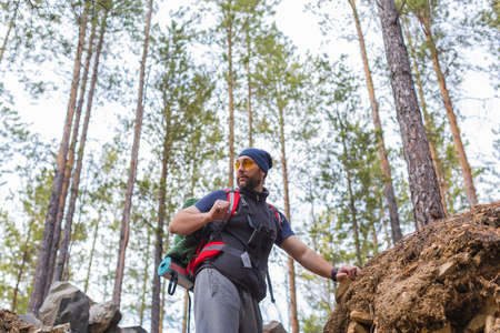 Bottom view of a hiking tourist walking through the trees in the highlands.