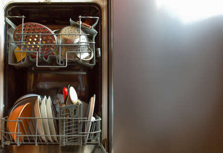 A close up view of a dishwasher loaded with dirty dishes.の写真素材