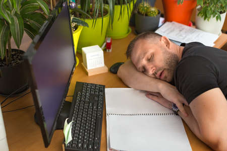 Male manager is sleeping in the workplace.