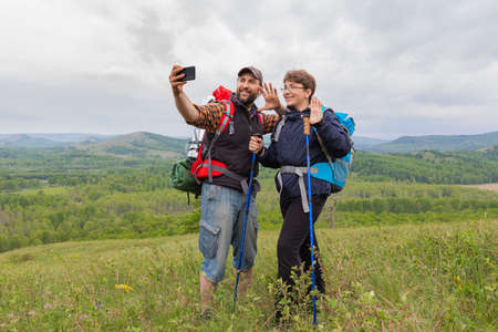 Father and son made a trip. Selfie on the top of the hill.の写真素材