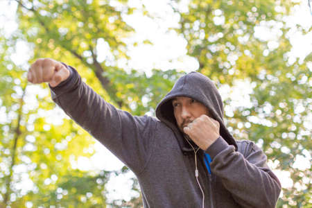 Boxing fighter workout in public park. Shadowfight.