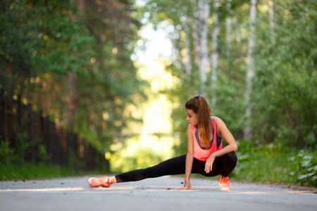 Woman warming up muscles before jogging. Sport and healthy lifestyle concept.