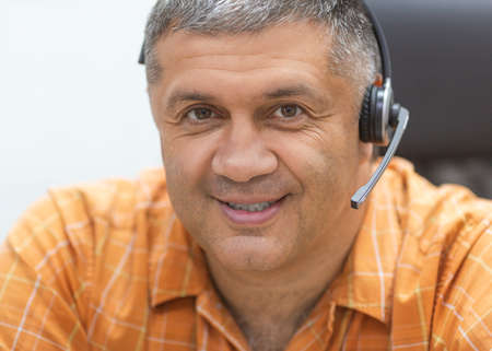 Online working concept. Smiley man with headset looking at camera.の写真素材