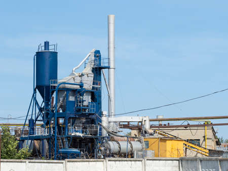Horizontal photo of a blue industrial building on a factory. Concrete factory