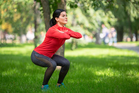 Woman doing exercises for legs in city park.の写真素材
