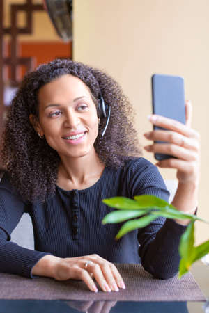 Vertical photo of an African woman having video call.