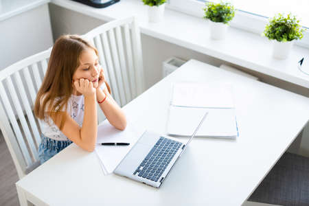 View a girl pupil in front of a laptop monitor during an online lesson.の写真素材
