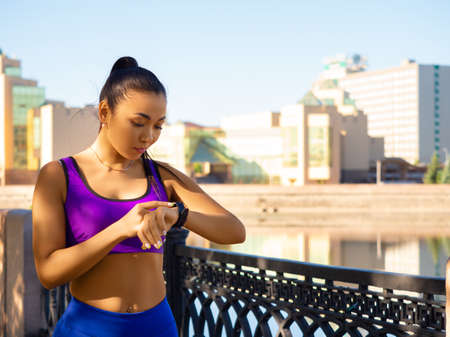 Photo of a young asian woman checks her pulse during the race.