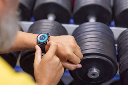 Hands of a man with a smart watch in the gym close-up.の写真素材