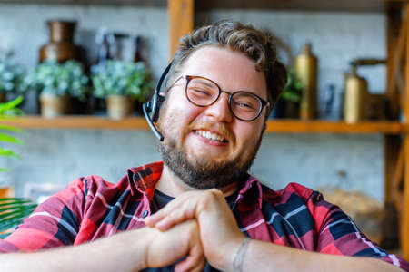 Happy laughing young man in headset during online video call.の写真素材
